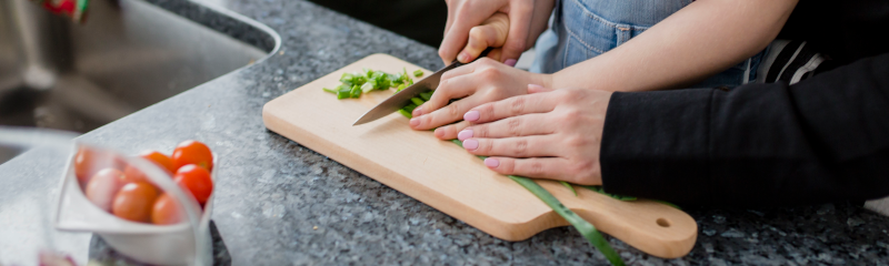 mom and daughter cutting vegetables in their kitchen